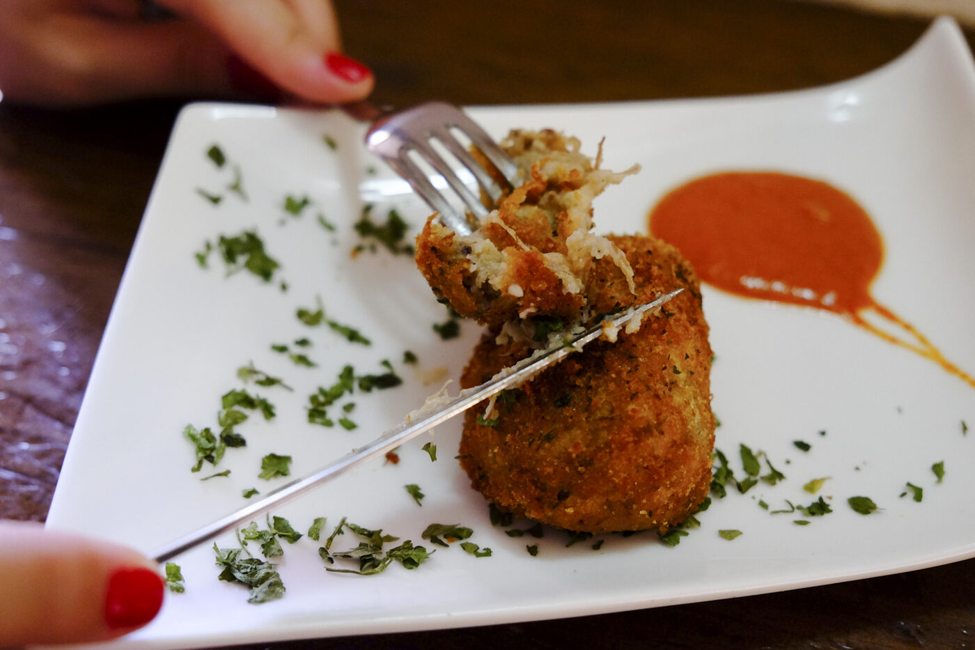 Croqueta con su salsa en el plato